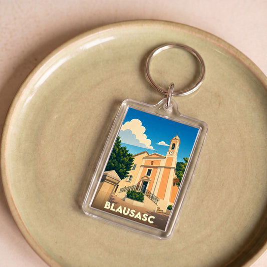 Porte-clés souvenir de la ville de Blausasc avec une illustration stylisée de son église.