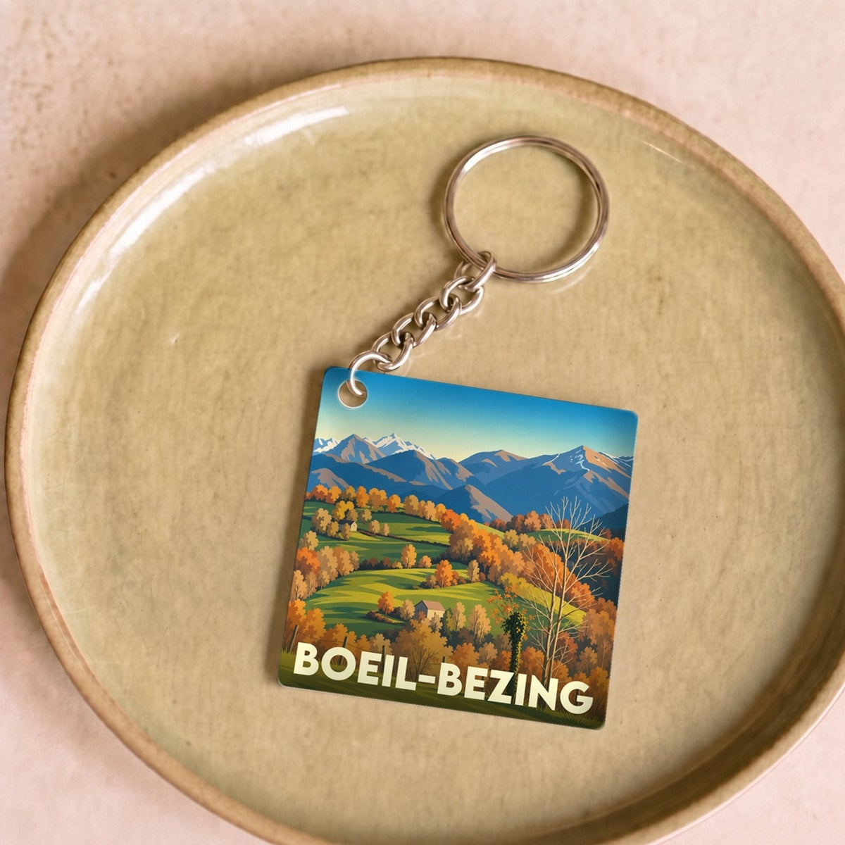 Porte-clés souvenir de la ville de Boeil-Bezing avec une illustration paysagère stylisée.