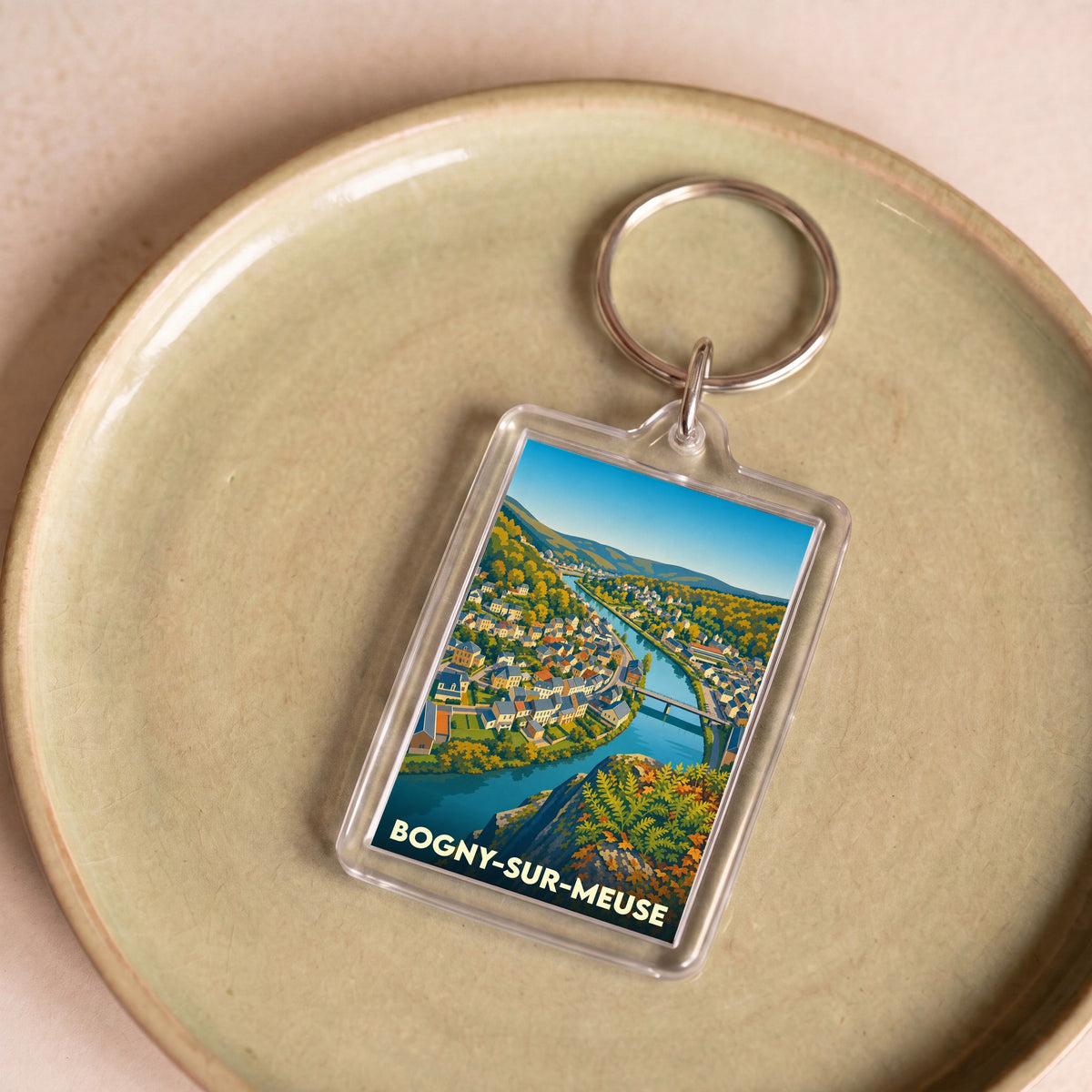 Porte-clés souvenir de la ville de Bogny-sur-Meuse avec une illustration stylisée de la Meuse serpentant entre les collines.