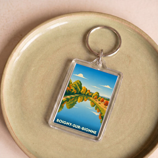 Porte-clés souvenir de la ville de Boigny-sur-Bionne avec une illustration stylisée d'un paysage d'automne.