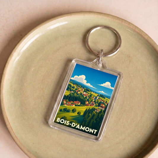 Porte-clés souvenir de la ville de Bois-d'Amont avec une illustration stylisée d'un paysage de montagne.