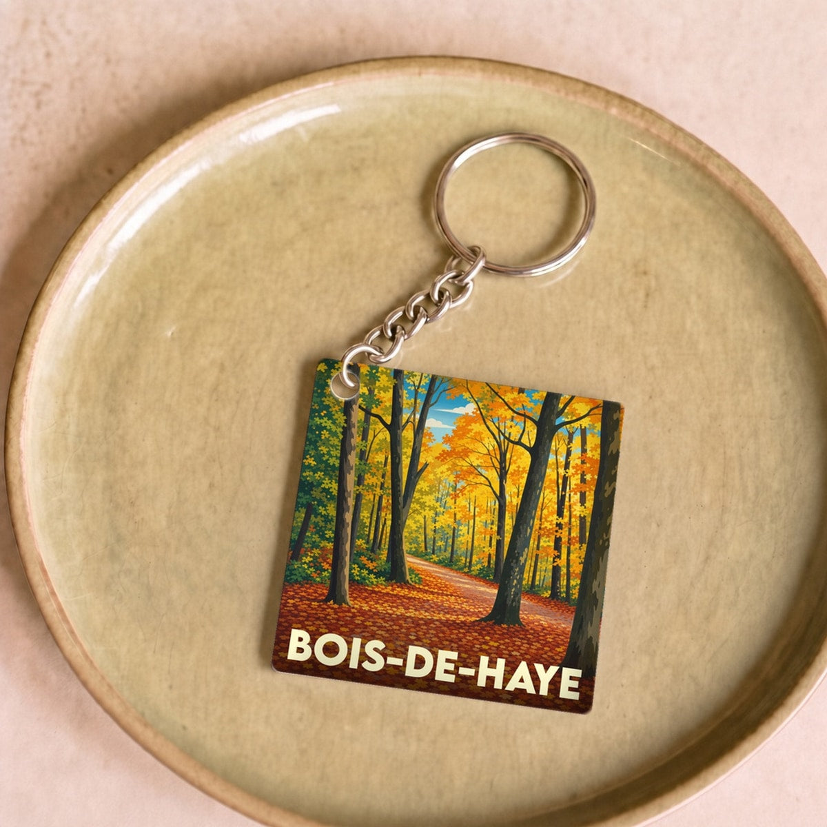 Porte-clés souvenir de Bois-de-Haye avec une illustration automnale de forêt.