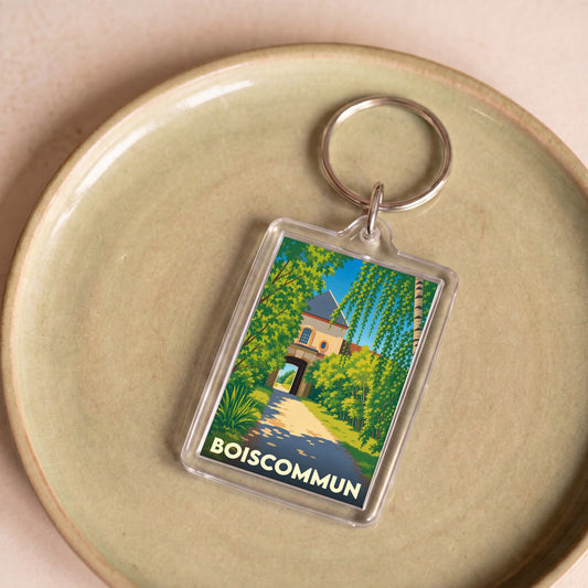 Porte-clés souvenir de la ville de Boiscommun avec une illustration stylisée.