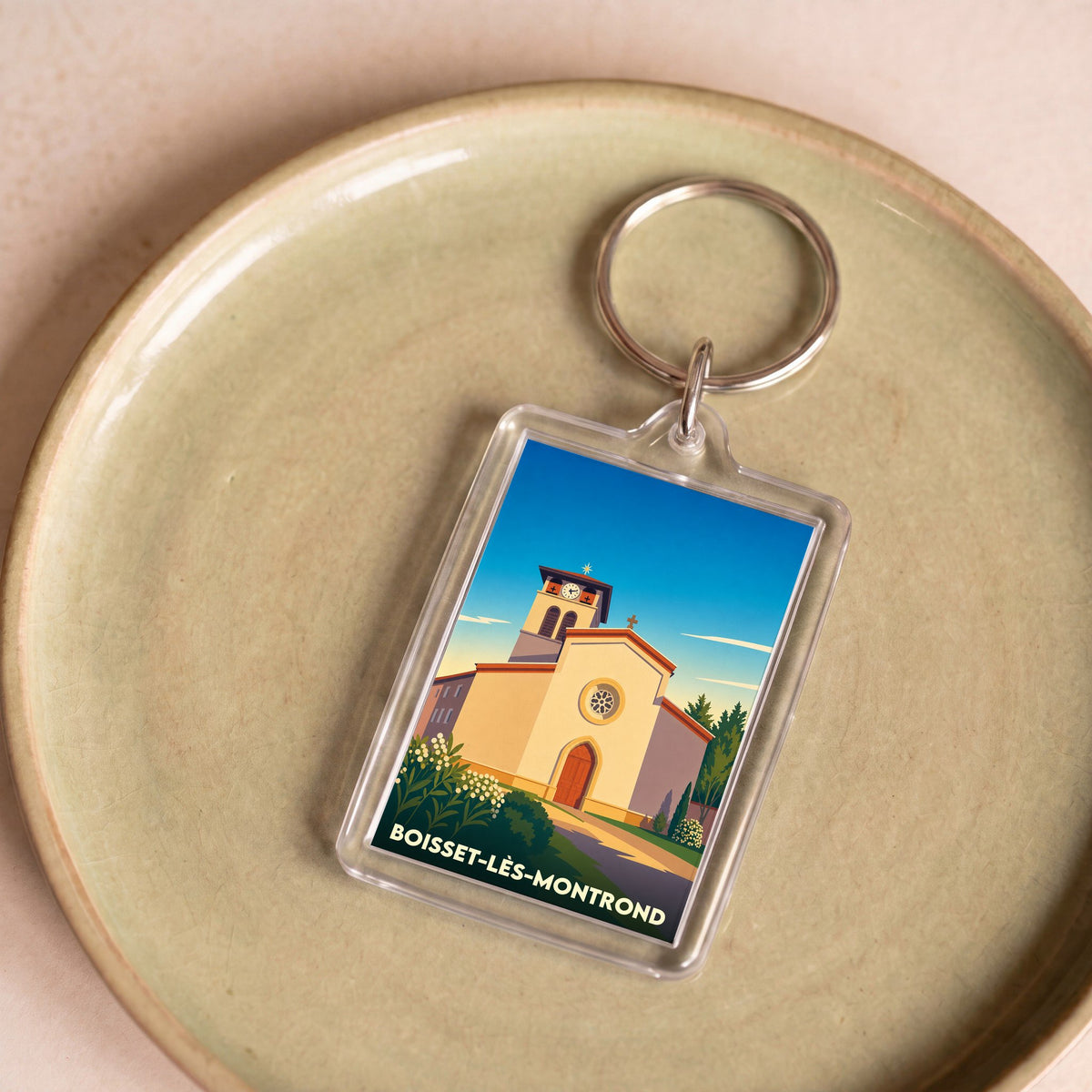 Porte-clés souvenir de la ville de Boisset-lès-Montrond avec une illustration stylisée de son église.