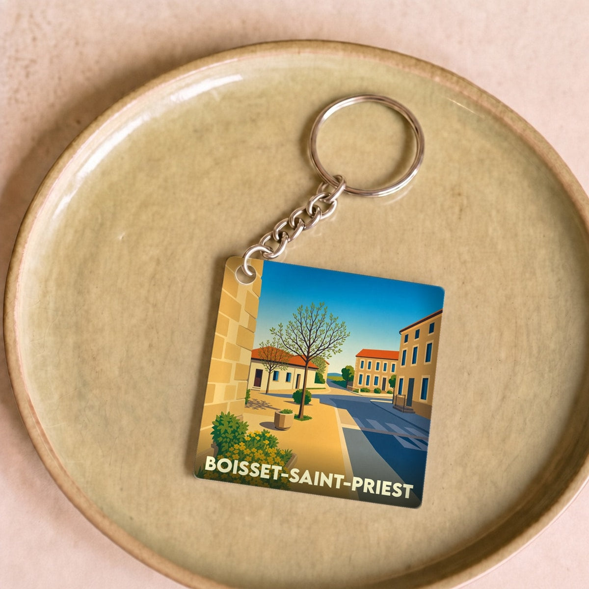 Porte-clés souvenir de la ville de Boisset-Saint-Priest avec une illustration stylisée.