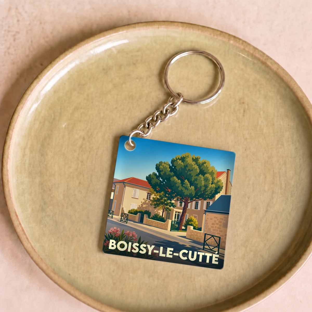 Porte-clés souvenir de la ville de Boissy-le-Cutté avec une illustration stylisée d'un paysage urbain.