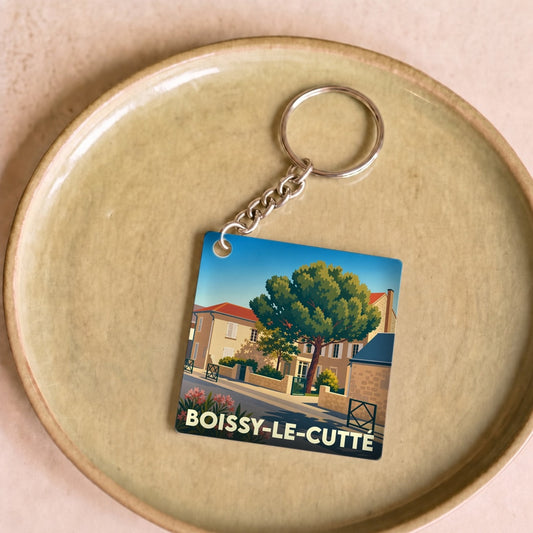Porte-clés souvenir de la ville de Boissy-le-Cutté avec une illustration stylisée d'un paysage urbain.