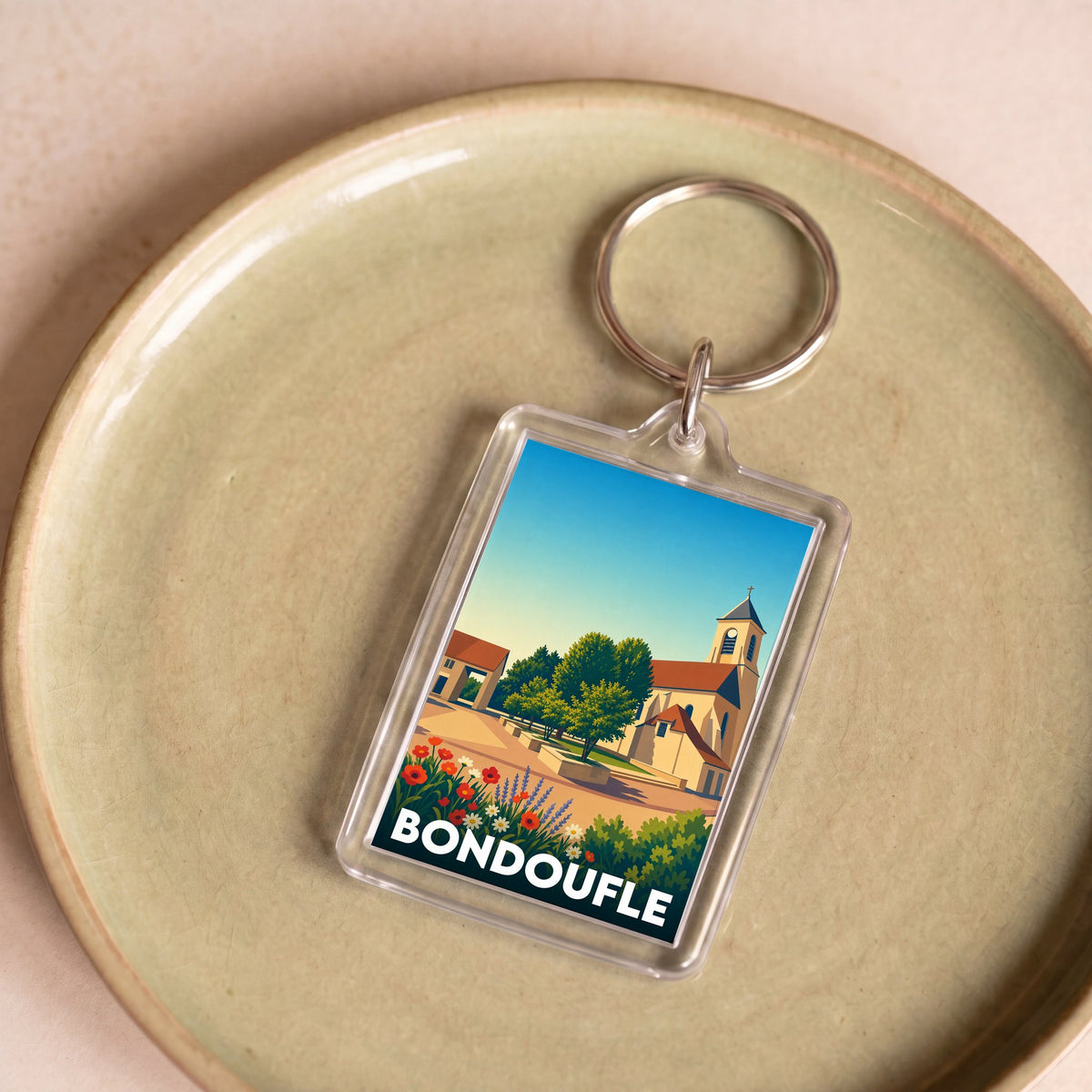Porte-clés souvenir de la ville de Bondoufle avec une illustration colorée et stylisée.