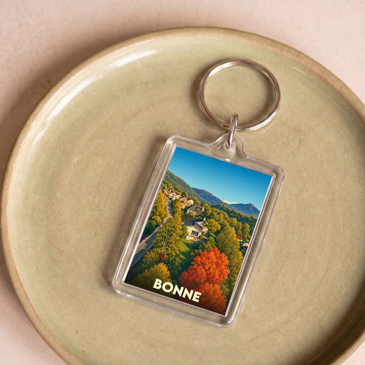 Porte-clés souvenir de la ville de Bonne avec une illustration stylisée d'un paysage d'automne.