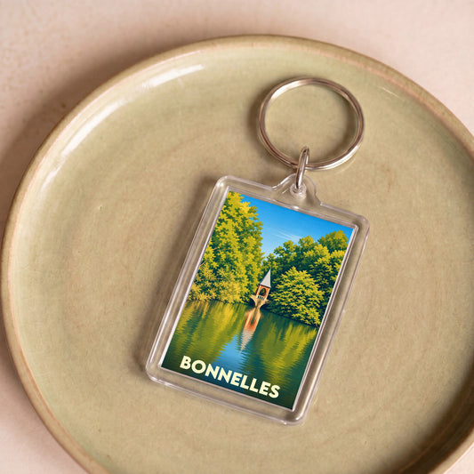 Porte-clés souvenir de la ville de Bonnelles avec une illustration stylisée d'un pavillon au bord de l'eau.