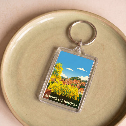 Porte-clés souvenir de la ville de Bormes-les-Mimosas avec une illustration stylisée.