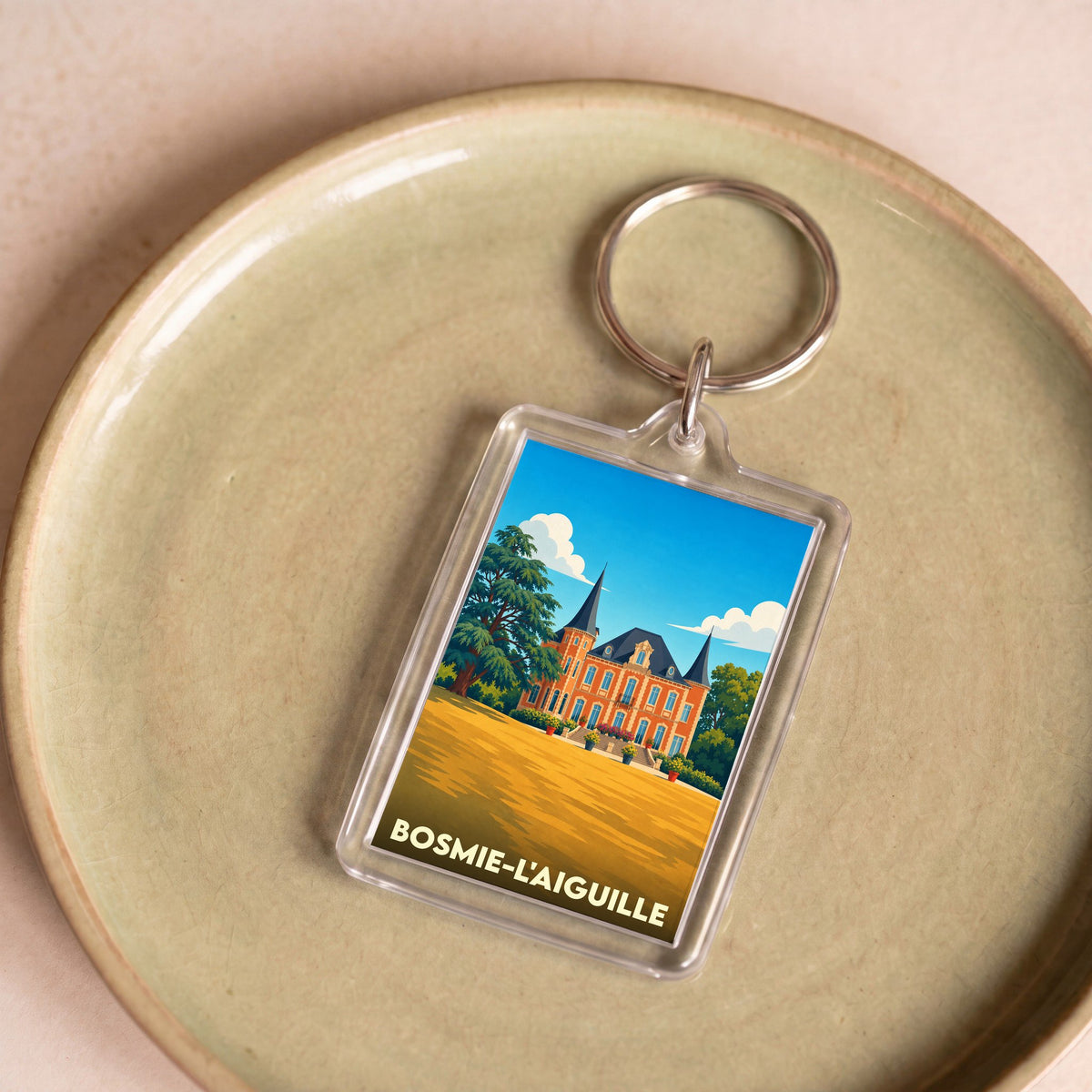 Porte-clés souvenir de la ville de Bosmie-l'Aiguille avec une illustration stylisée de son château.