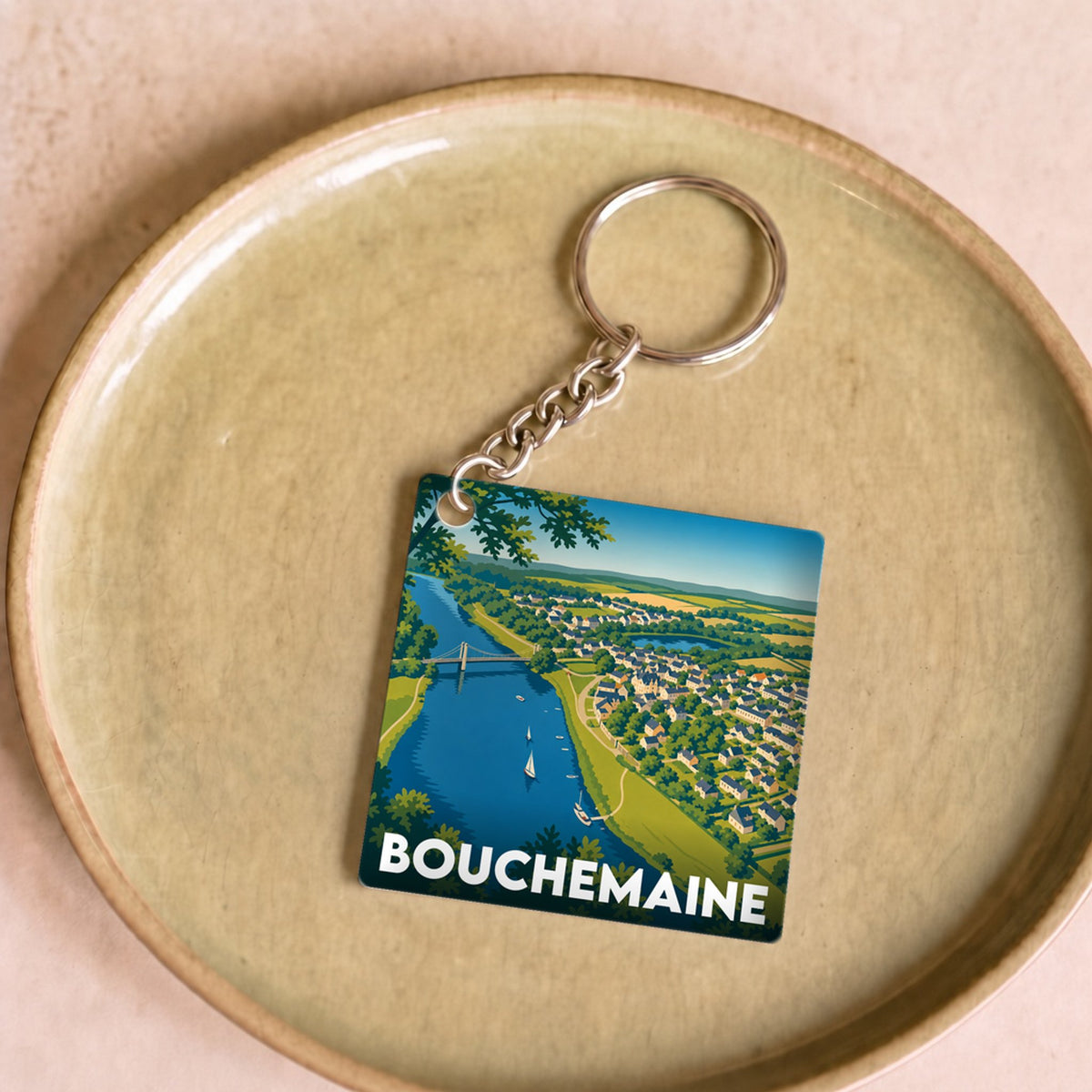 Porte-clés souvenir de la ville de Bouchemaine avec une illustration paysagère stylisée.