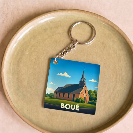 Porte-clés souvenir de la ville de Boué avec une illustration stylisée de son église.
