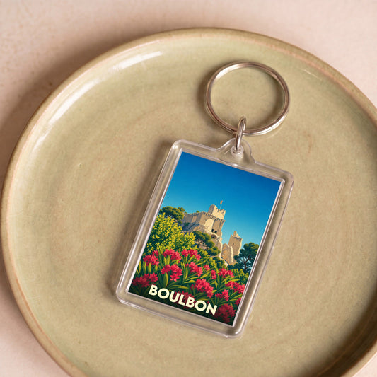 Porte-clés souvenir de la ville de Boulbon avec une illustration stylisée de son château médiéval.