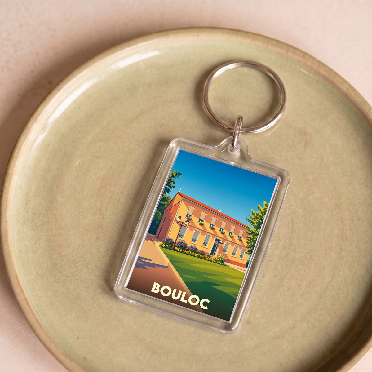 Porte-clés souvenir de la ville de Bouloc avec une illustration stylisée.