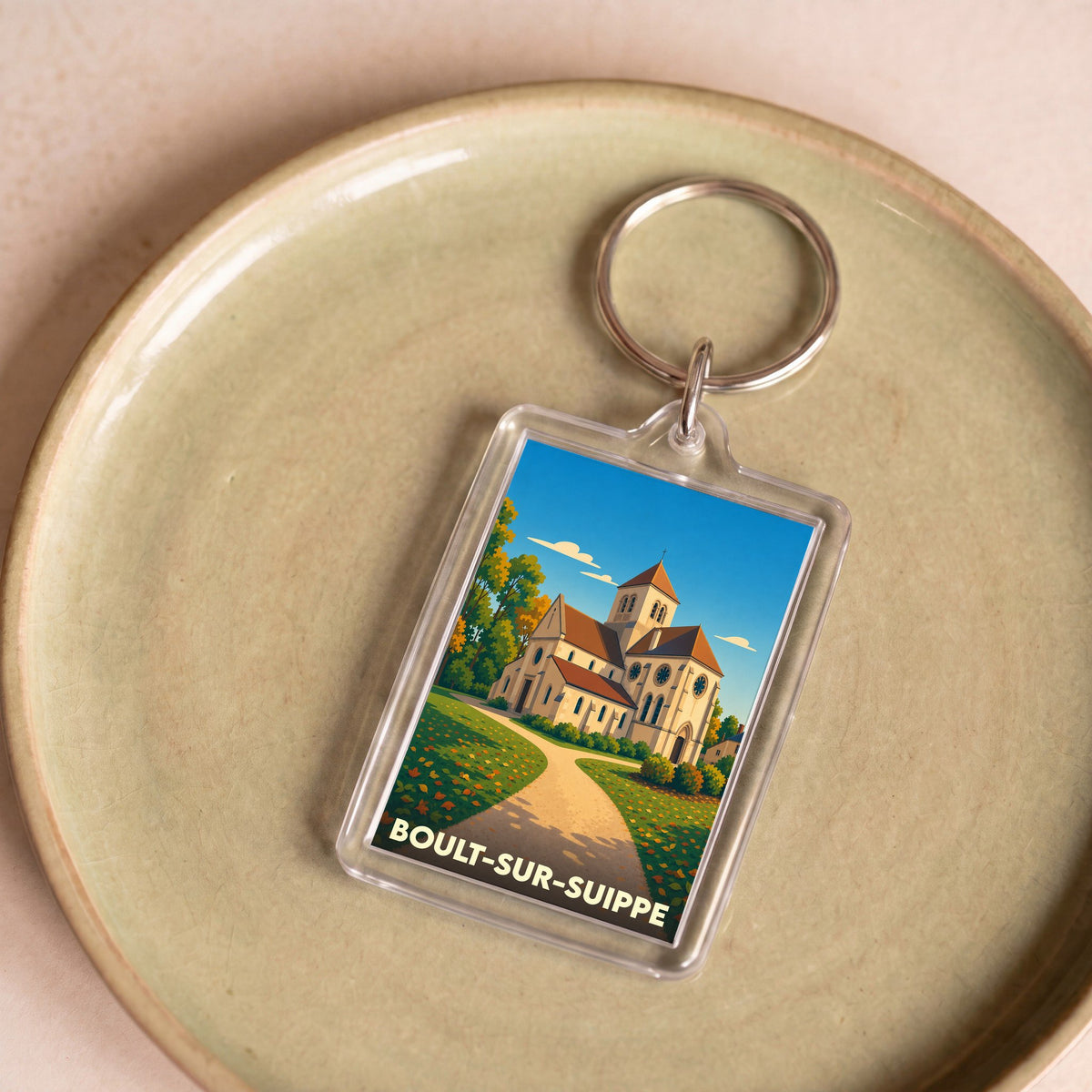 Porte-clés souvenir de la ville de Boult-sur-Suippe avec une illustration stylisée de son église.