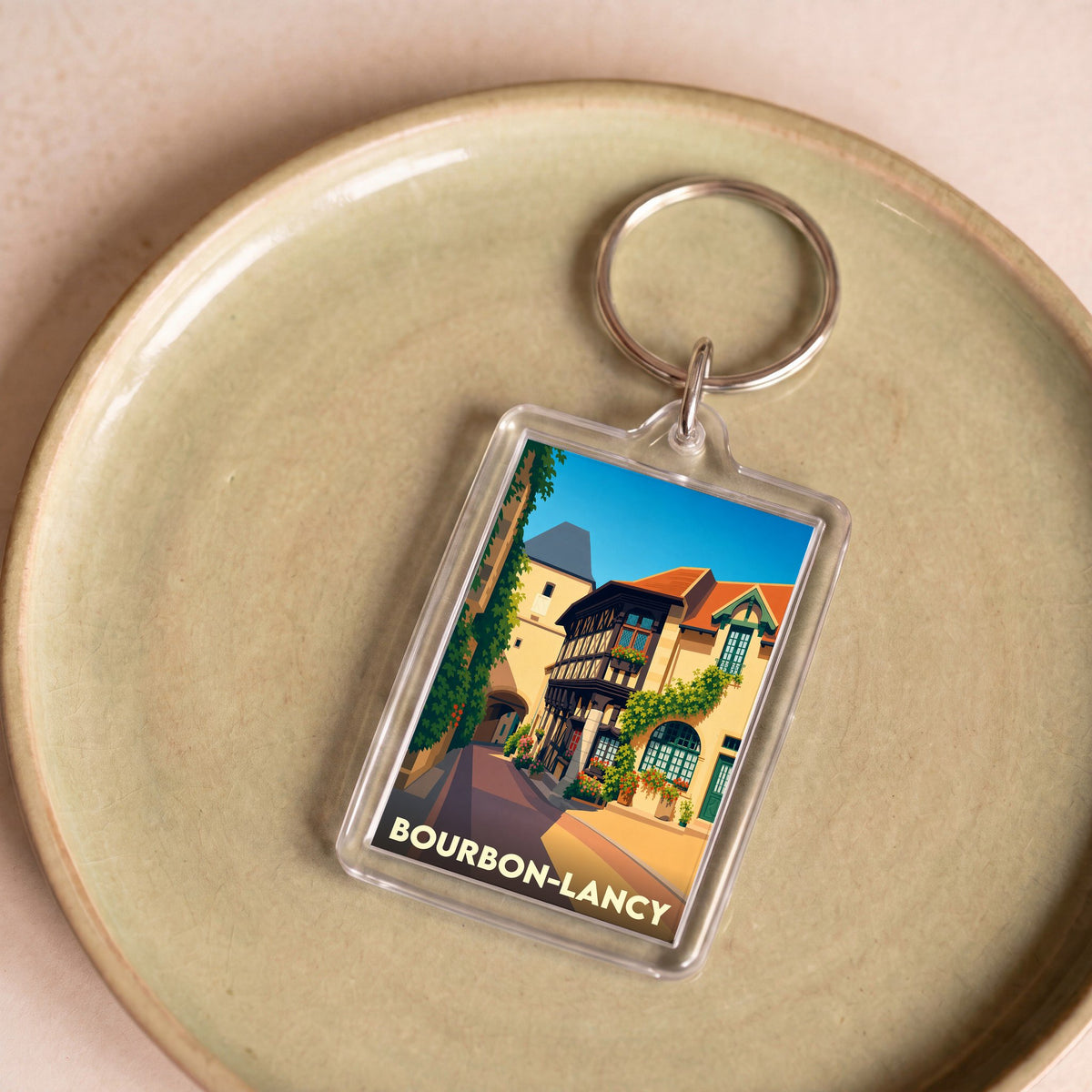 Porte-clés souvenir de la ville de Bourbon-Lancy avec une illustration stylisée de ses maisons à colombages.