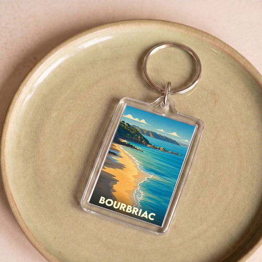Porte-clés souvenir de la ville de Bourbriac avec une illustration stylisée d'un bord de mer.