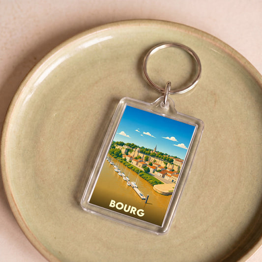Porte-clés souvenir de la ville de Bourg avec une illustration stylisée d'un port au pied d'une falaise.