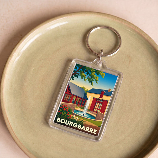 Porte-clés souvenir de la ville de Bourgbarré avec une illustration stylisée d'une fontaine et de bâtiments colorés.
