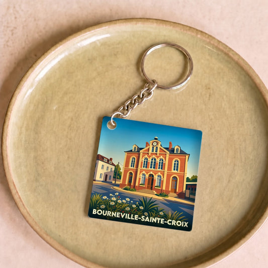 Porte-clés souvenir de la ville de Bourneville-Sainte-Croix avec une illustration stylisée de son architecture.