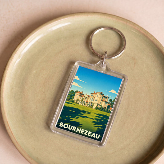 Porte-clés souvenir de la ville de Bournezeau avec une illustration stylisée d'un château sur un fond de paysage.