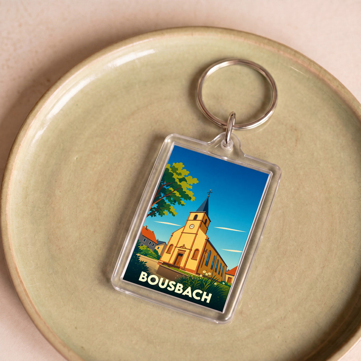 Porte-clés souvenir de la ville de Bousbach avec une illustration stylisée de son église.