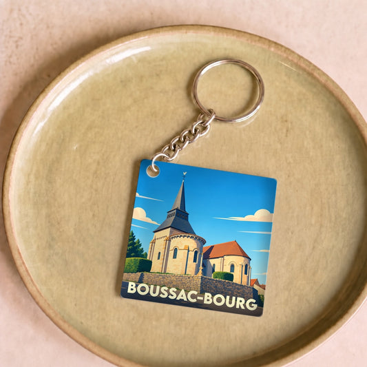 Porte-clés souvenir de la ville de Boussac-Bourg avec une illustration stylisée de son église.