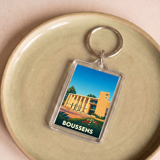 Porte-clés souvenir de la ville de Boussens avec une illustration stylisée.