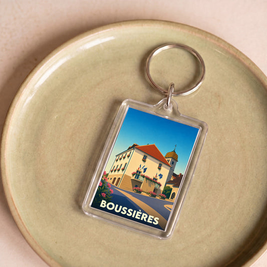 Porte-clés souvenir de la ville de Boussières avec une illustration stylisée.