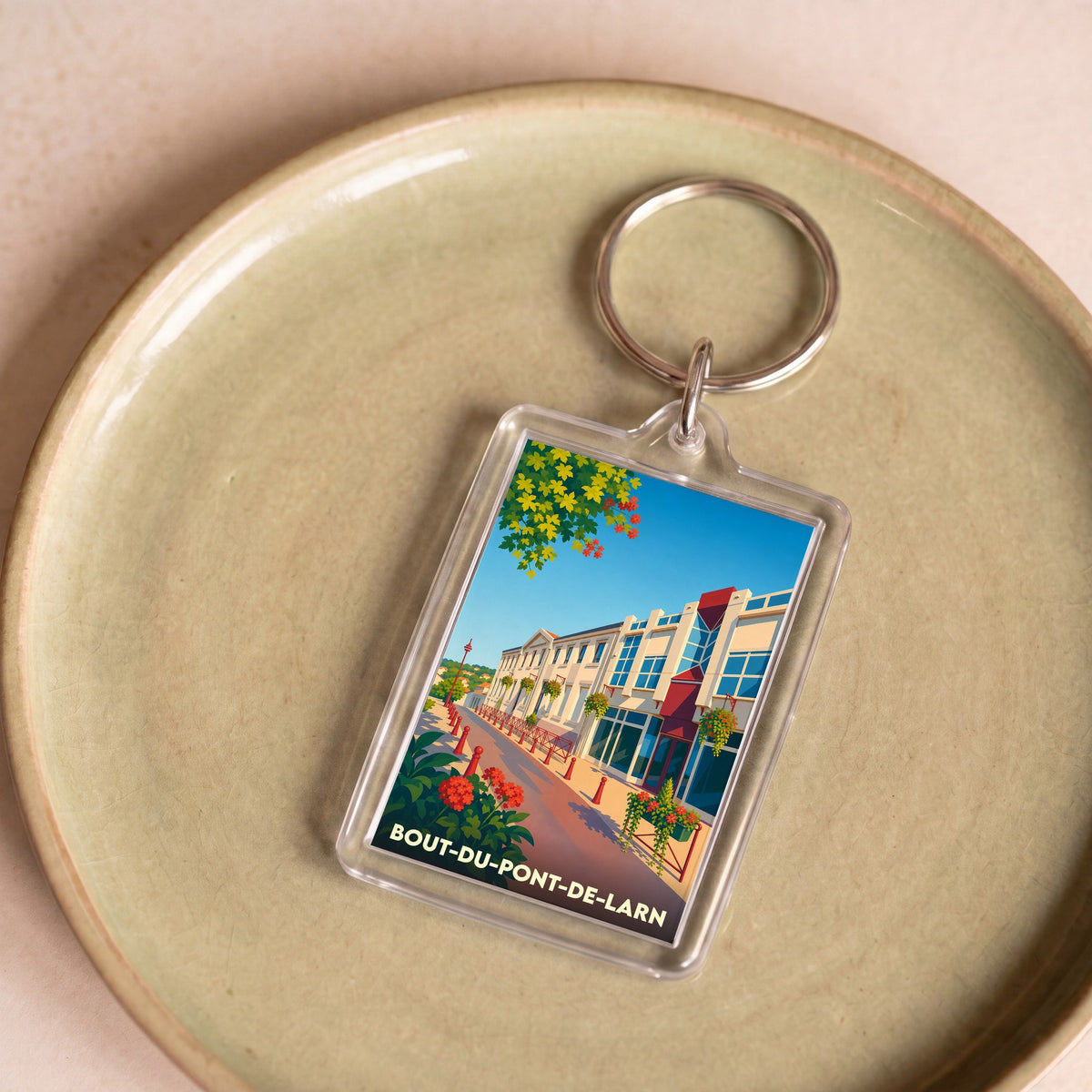 Porte-clés souvenir de Bout-du-Pont-de-Larn avec une illustration stylisée de la ville.