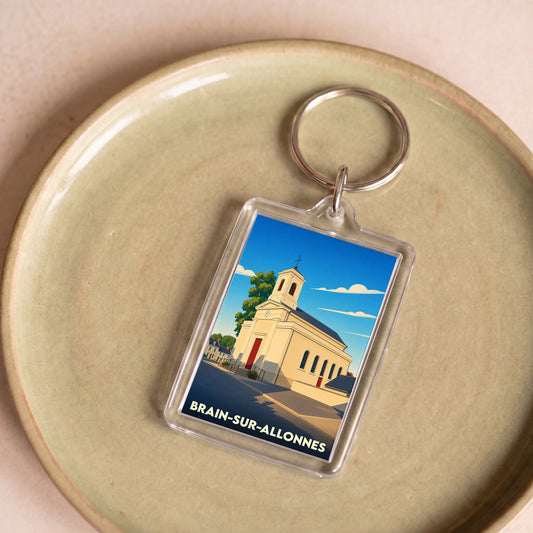Porte-clés souvenir de la ville de Brain-sur-Allonnes avec une illustration stylisée de son église.