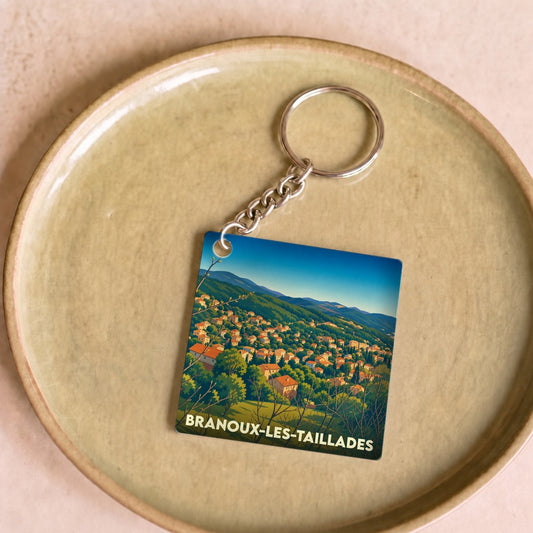 Porte-clés souvenir de la ville de Branoux-les-Taillades avec une illustration paysagère stylisée.