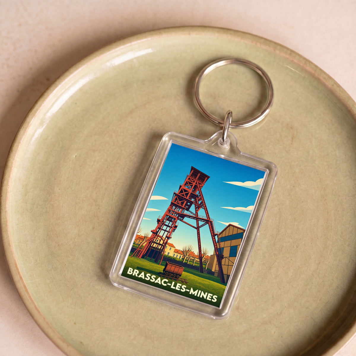 Porte-clés souvenir de la ville de Brassac-les-Mines avec une illustration stylisée d'un chevalement de mine.