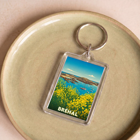 Porte-clés souvenir de la ville de Bréhal avec une illustration stylisée du littoral.