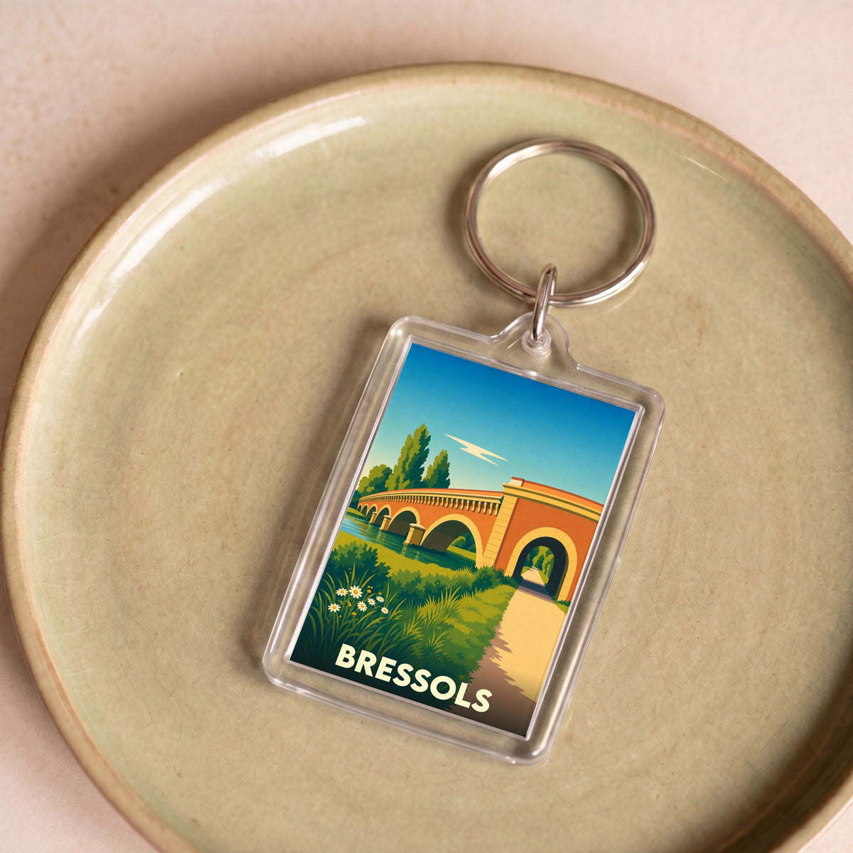 Porte-clés souvenir de la ville de Bressols avec une illustration stylisée d'un pont en briques.