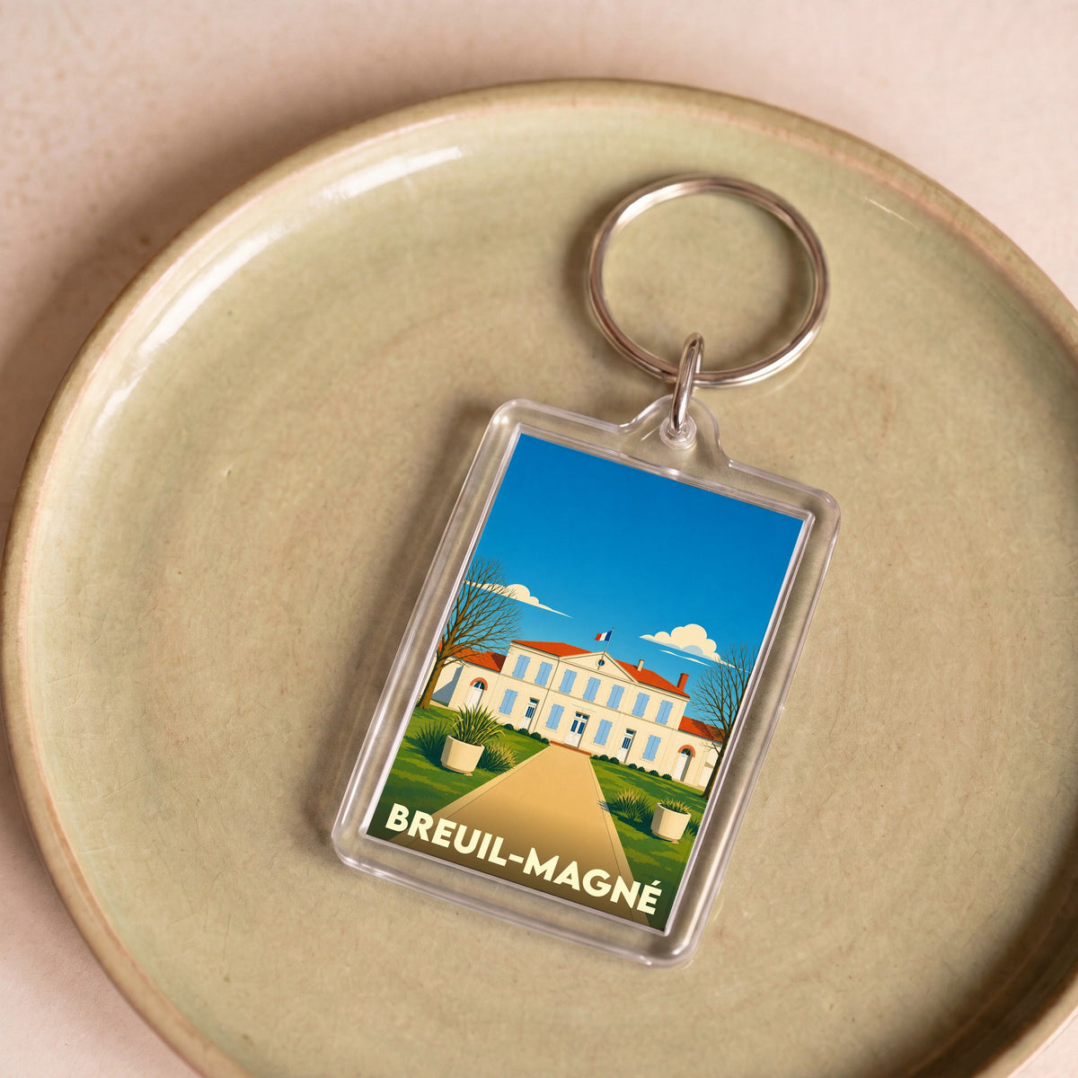 Porte-clés souvenir de la ville de Breuil-Magné avec une illustration stylisée de sa mairie.