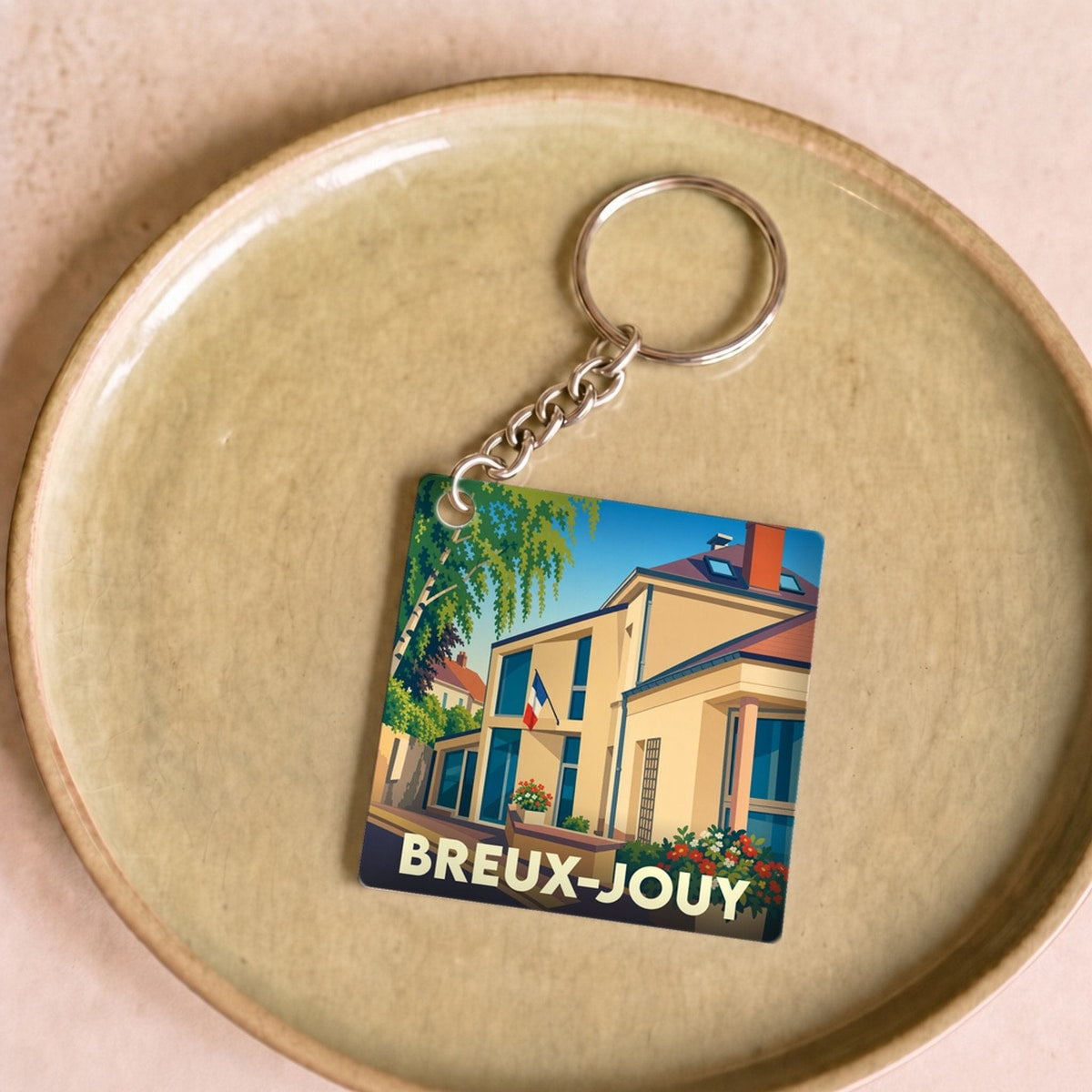 Porte-clés souvenir de la ville de Breux-Jouy avec une illustration stylisée de la mairie.