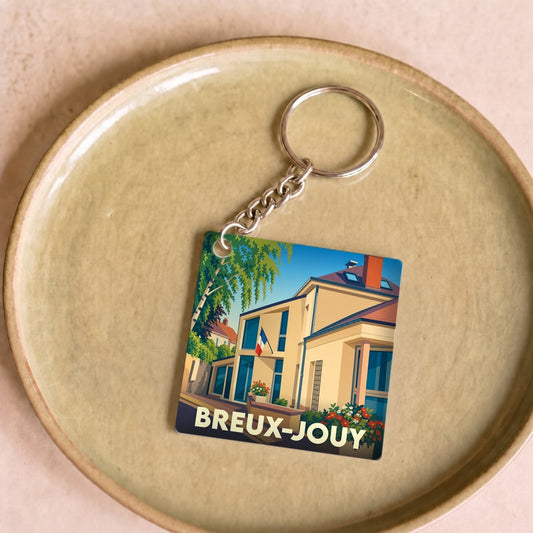 Porte-clés souvenir de la ville de Breux-Jouy avec une illustration stylisée de la mairie.