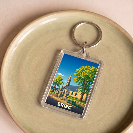 Porte-clés souvenir de la ville de Briec avec une illustration stylisée d'une église et de grands arbres.