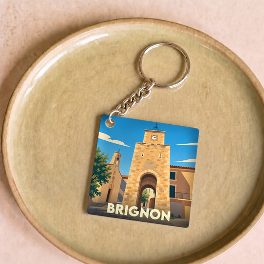 Porte-clés souvenir de la ville de Brignon avec une illustration stylisée de son patrimoine architectural.