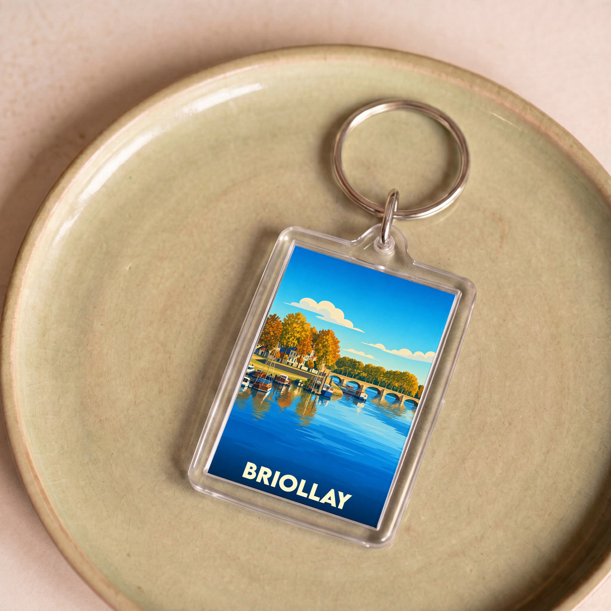 Porte-clés souvenir de la ville de Briollay avec une illustration stylisée des bords de la Mayenne.