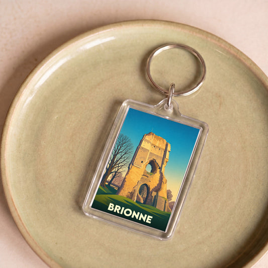 Porte-clés souvenir de la ville de Brionne avec une illustration stylisée de son donjon historique.