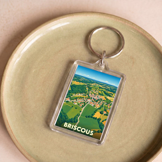 Porte-clés souvenir de la ville de Briscous avec une illustration aérienne stylisée.