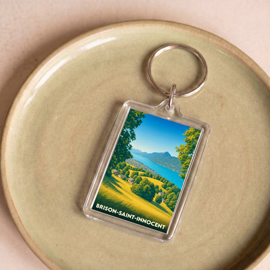 Porte-clés souvenir de la ville de Brison-Saint-Innocent avec une illustration stylisée du lac et des montagnes.