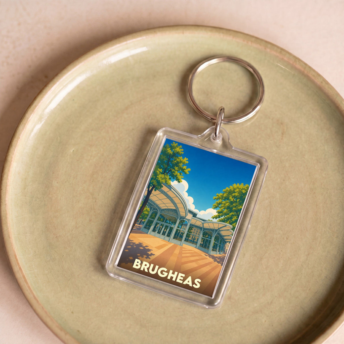 Porte-clés souvenir de la ville de Brugheas avec une illustration stylisée.
