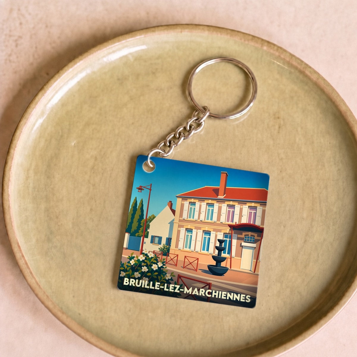 Porte-clés souvenir de la ville de Bruille-lez-Marchiennes avec une illustration stylisée.