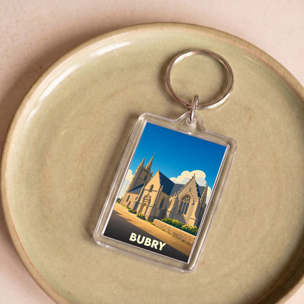 Porte-clés souvenir de la ville de Bubry avec une illustration stylisée de son église.