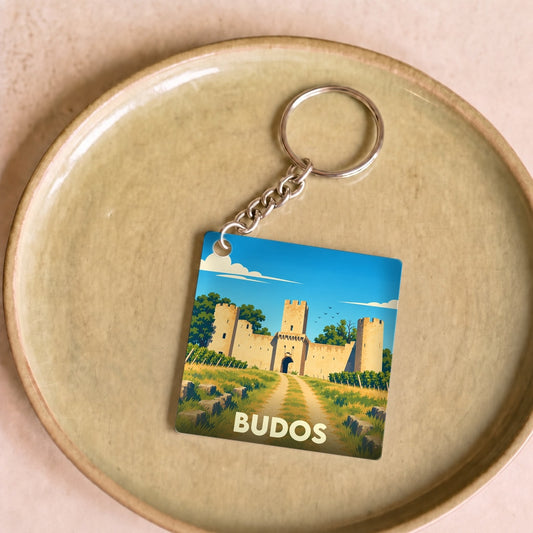 Porte-clés souvenir de la ville de Budos avec une illustration stylisée de son château médiéval.